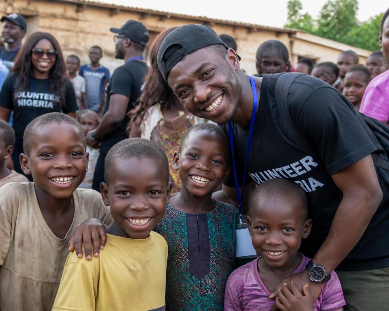 Volunteers and children smiling together at a community outreach